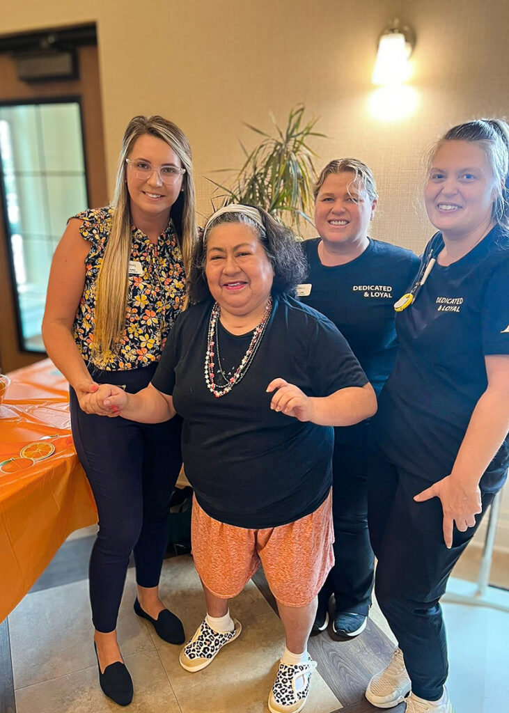 Team members and a resident smile together at The Westbury.